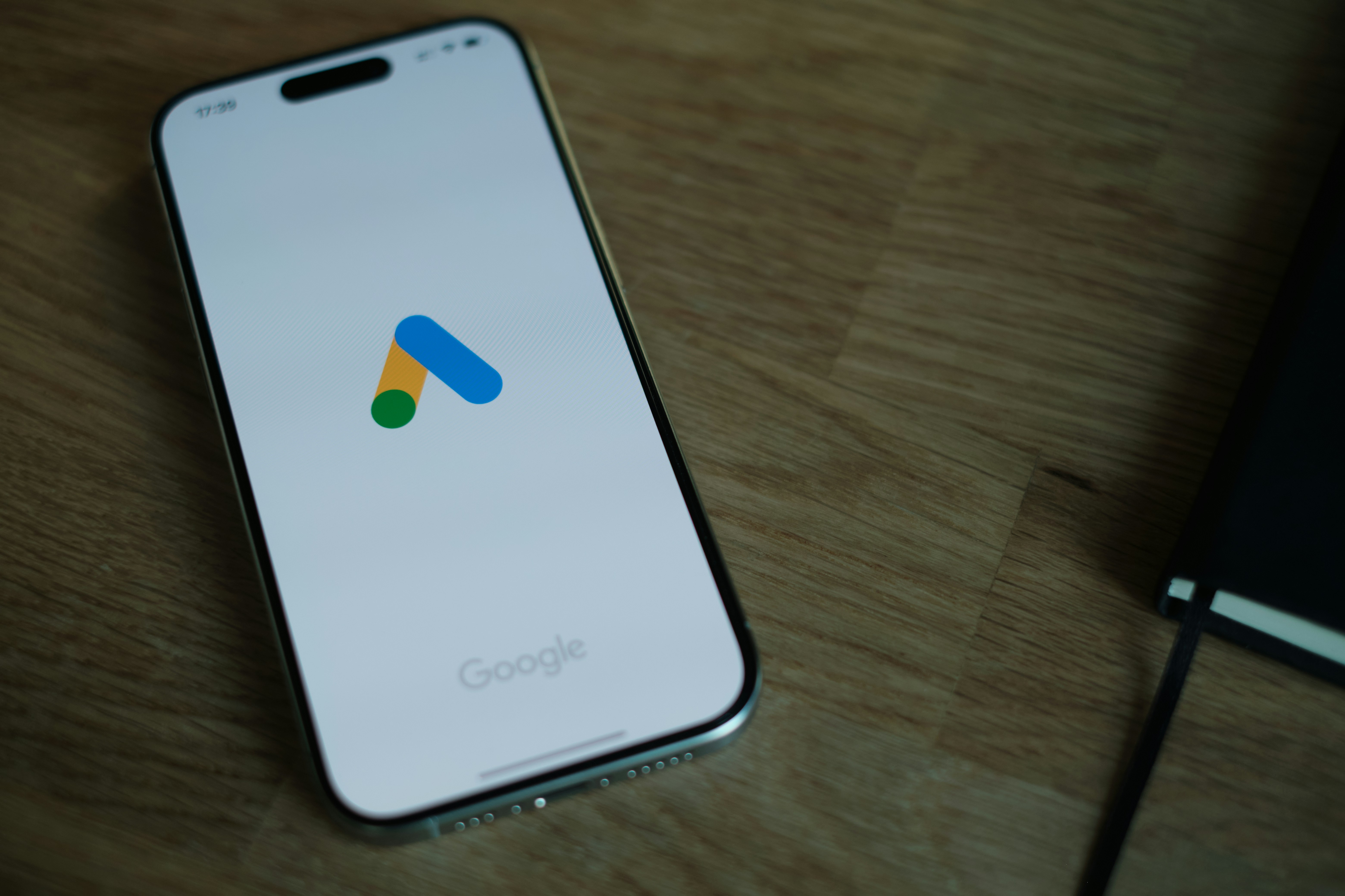 A smartphone with a ring of colored light around its rear camera module, resting face down on a surface.